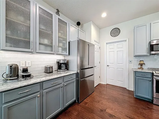 a kitchen with granite countertop a refrigerator stove top oven and sink
