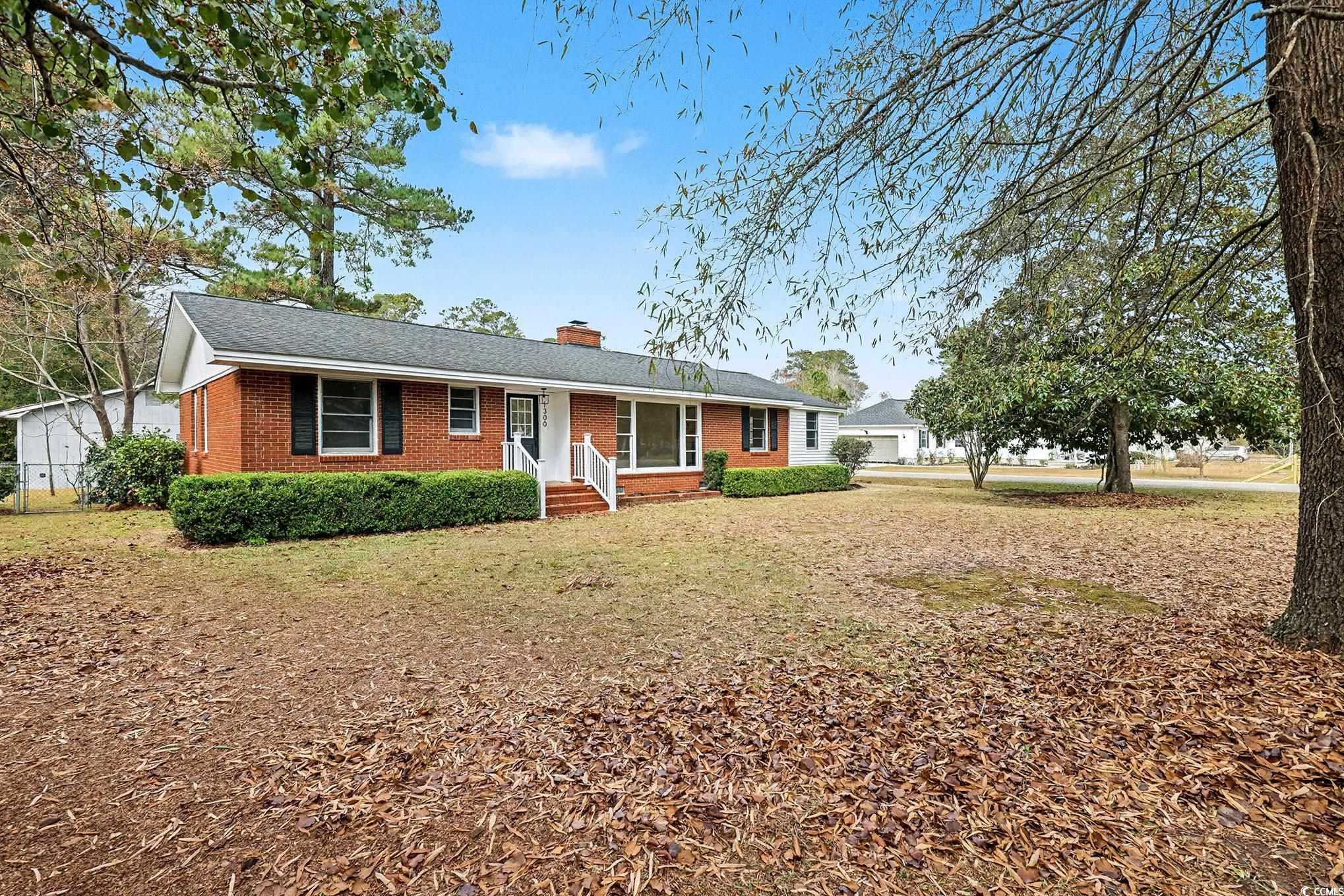 Ranch-style home with brick siding and a chimney
