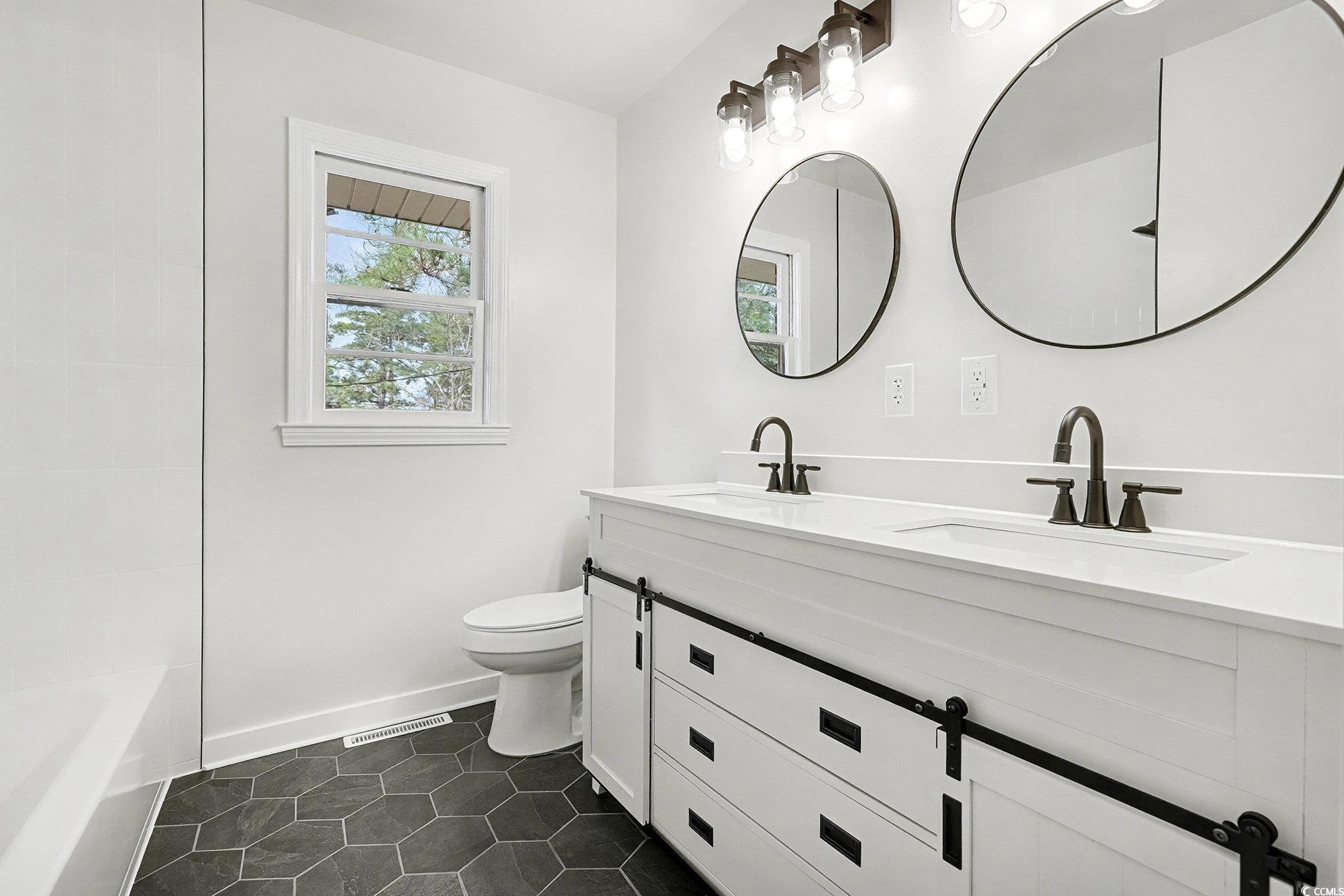 1300 Anderson Street Conway, SC 29526 - Photo 13 of 21 Bathroom with double vanity, dark tile patterned flooring, and tub / shower combination