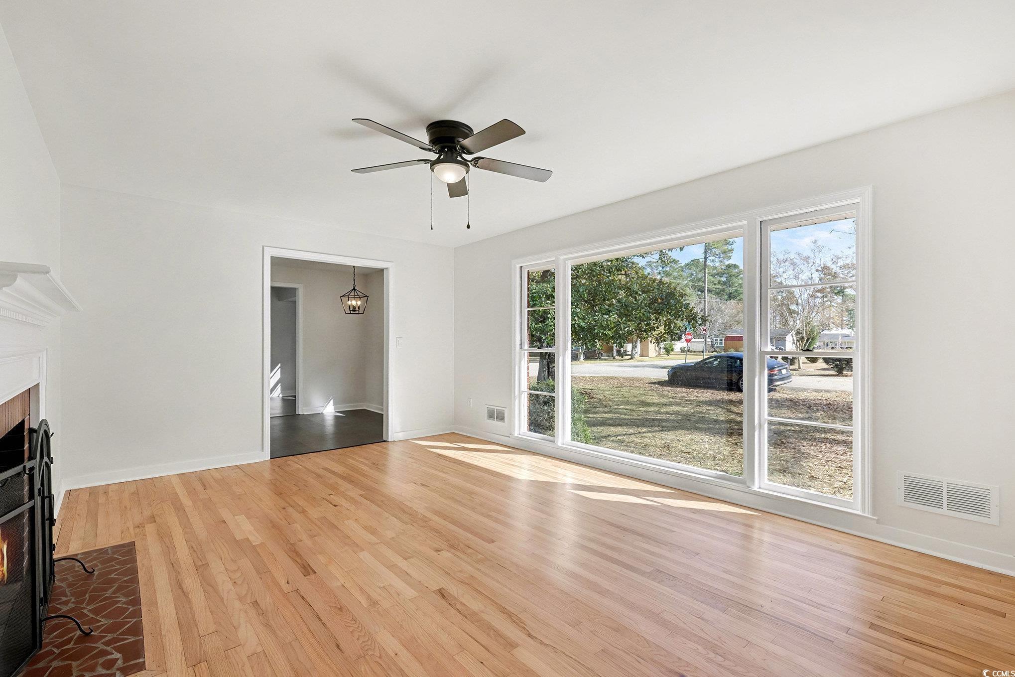 1300 Anderson Street Conway, SC 29526 - Photo 8 of 21 Unfurnished living room featuring a brick fireplace, light wood finished floors, and a ceiling fan