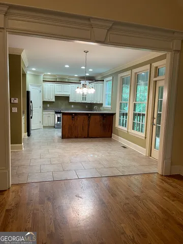 a room with stainless steel appliances kitchen island granite countertop a refrigerator a sink and a wooden cabinets