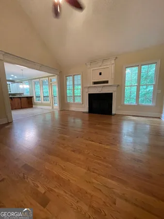 an empty room with windows and fireplace