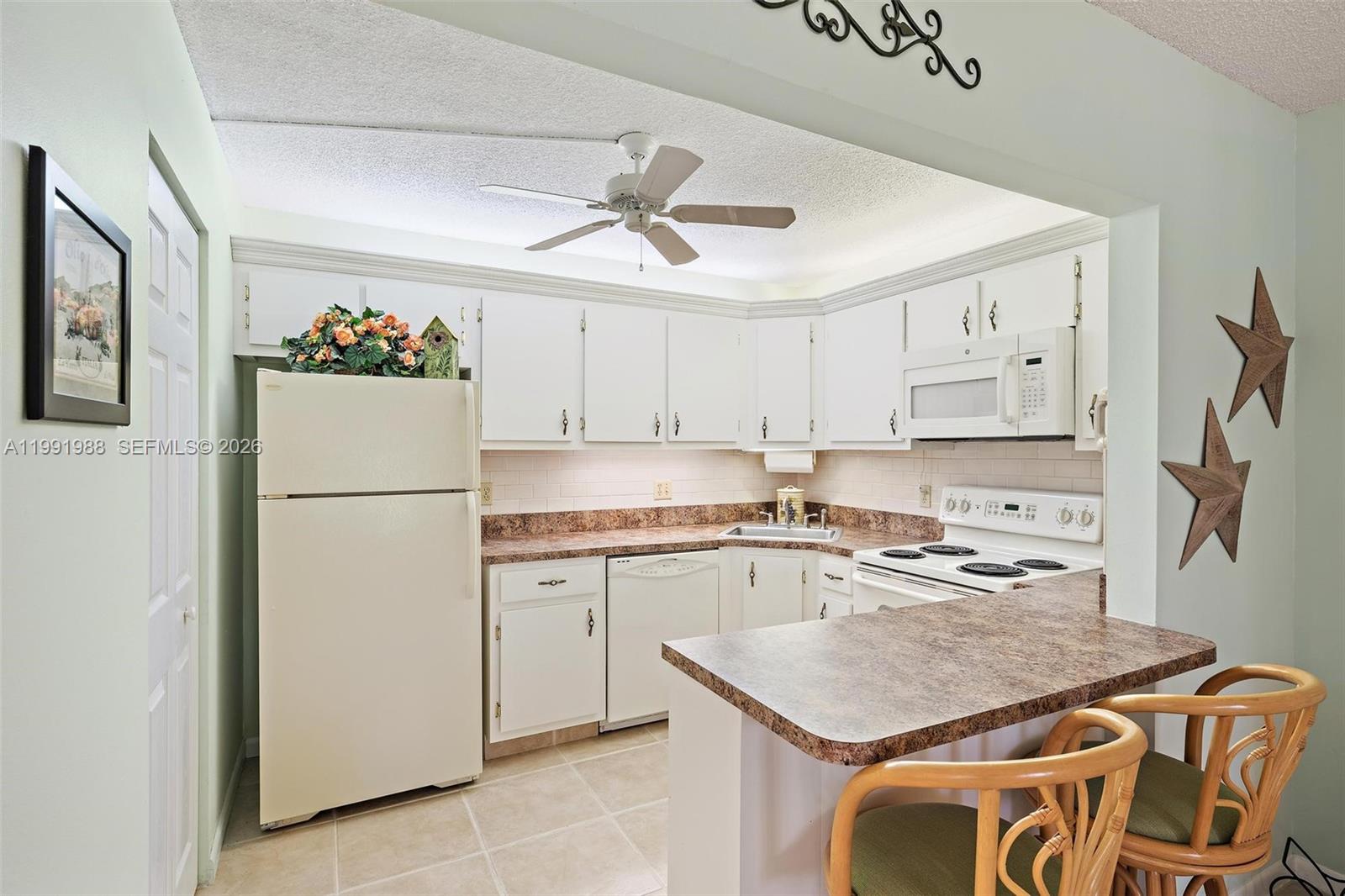 301 Pine Ridge Circle, Unit C1 Greenacres, FL 33463 - Photo 12 of 30 a kitchen with stainless steel appliances granite countertop a refrigerator a stove a sink dishwasher and white cabinets with wooden floor