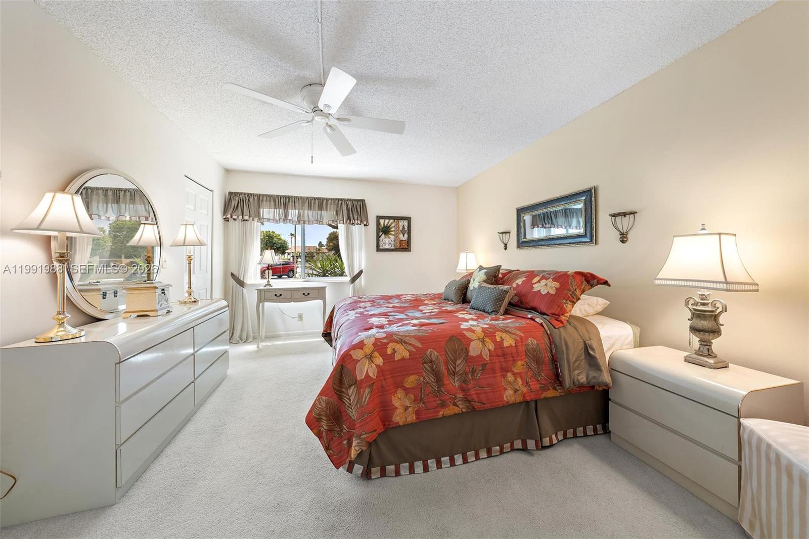 301 Pine Ridge Circle, Unit C1 Greenacres, FL 33463 - Photo 16 of 30 a spacious bedroom with a bed a table and painting
