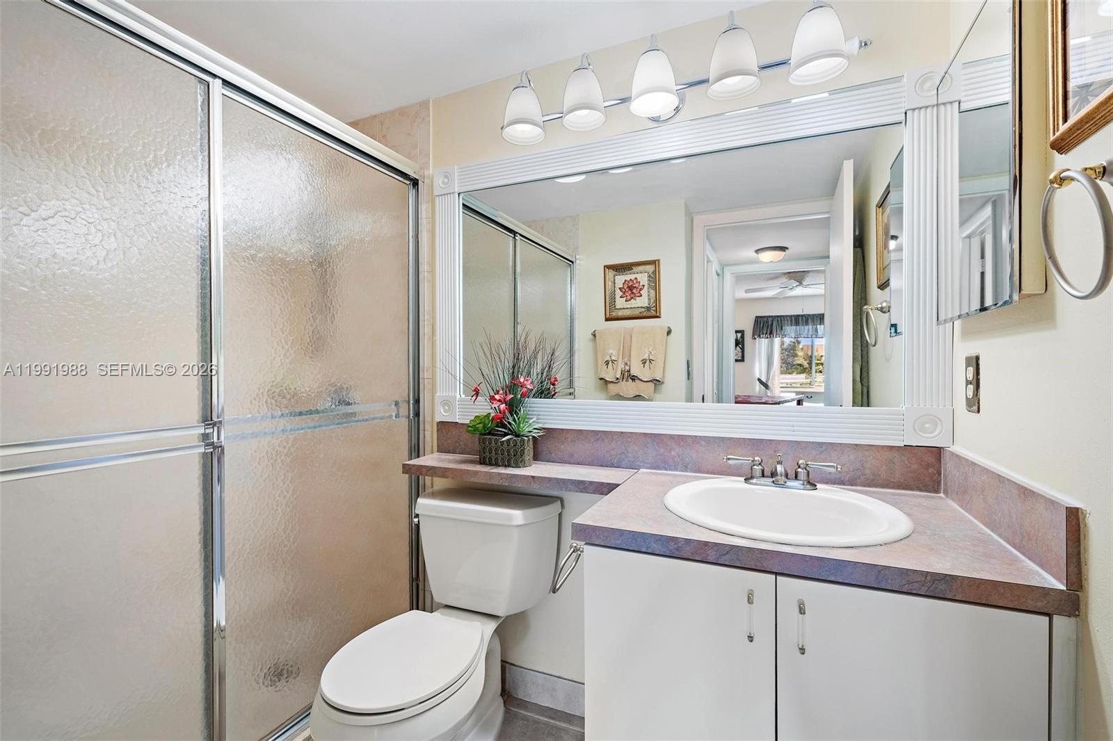 301 Pine Ridge Circle, Unit C1 Greenacres, FL 33463 - Photo 19 of 30 a bathroom with a sink toilet a mirror and shower