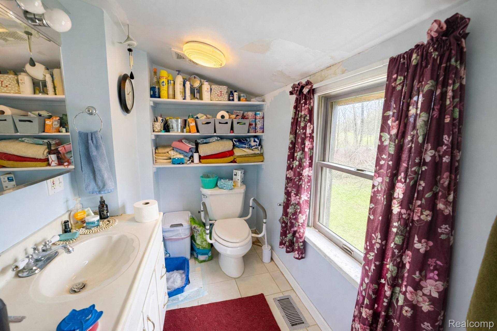 10044 Locust Drive Fenton, MI 48430 - Photo 12 of 20 Full bath with vanity, lofted ceiling, light tile patterned flooring, and shower / bathtub combination with curtain