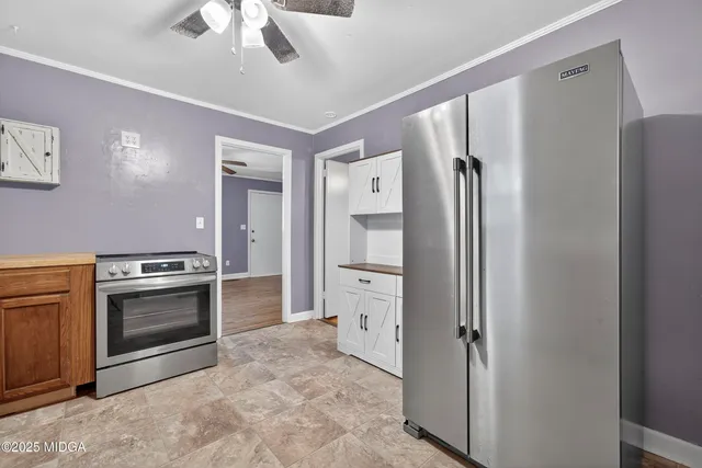 a kitchen with a refrigerator and a stove top oven