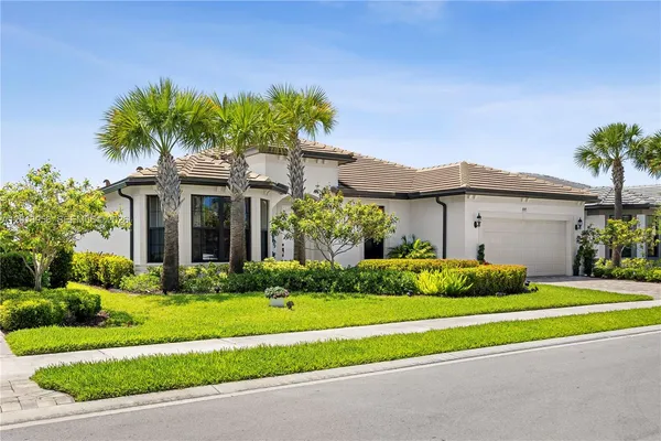 a front view of a house with a yard and potted plants