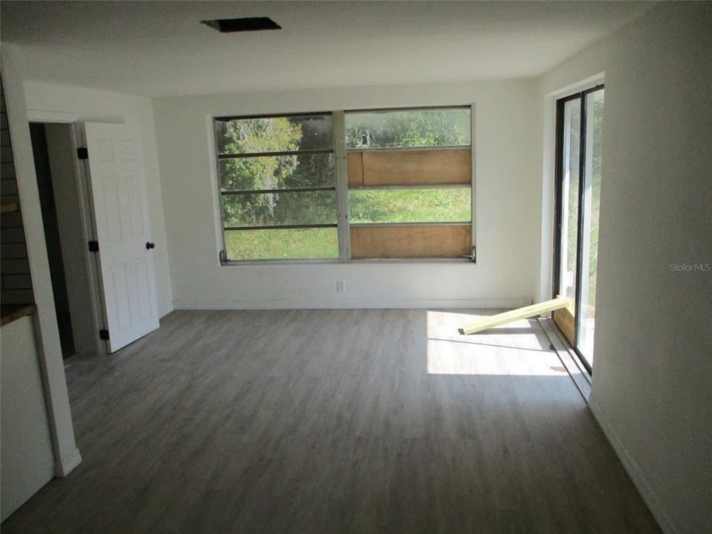 7925 Bracken Drive Port Richey, FL 34668 - Photo 3 of 11 an empty room with wooden floor and windows