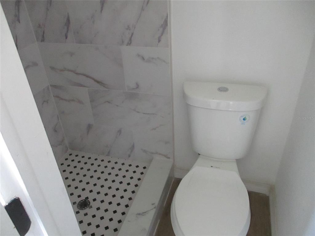7925 Bracken Drive Port Richey, FL 34668 - Photo 8 of 11 a bathroom with a toilet and a shower