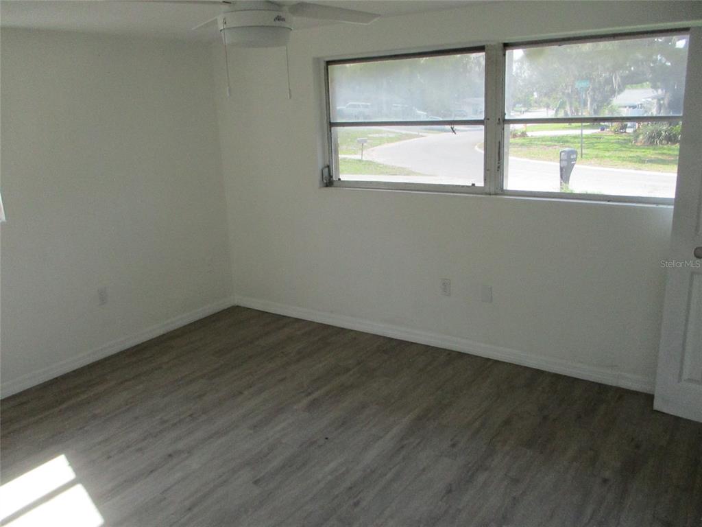 7925 Bracken Drive Port Richey, FL 34668 - Photo 10 of 11 an empty room with wooden floor and windows