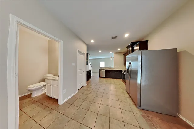 a view of a refrigerator in kitchen and a window