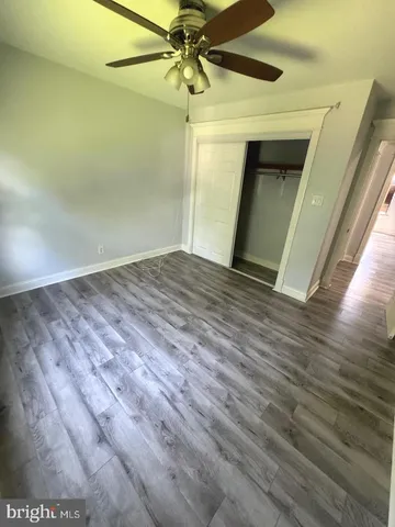 a view of a livingroom with a kitchen space with wooden floor