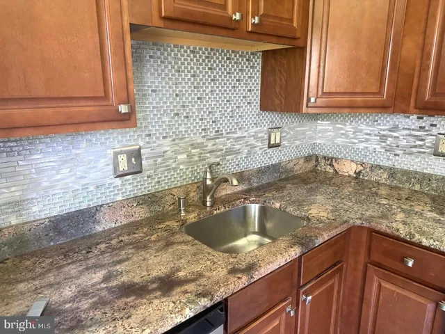 a kitchen with granite countertop a sink and cabinets