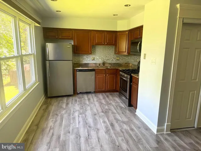 a kitchen with stainless steel appliances granite countertop a refrigerator sink and cabinets