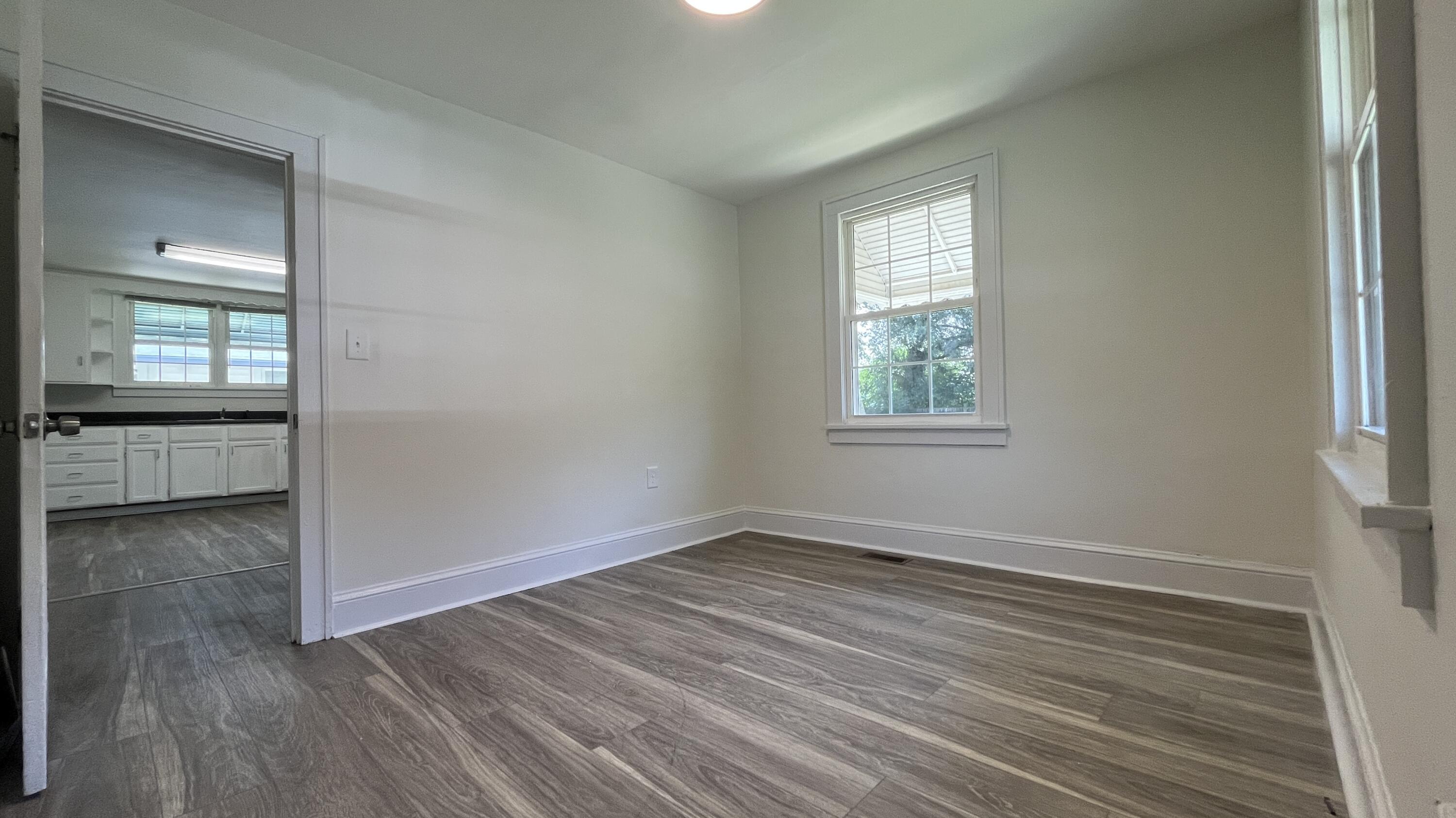 4042 Tennessee Avenue Northwest Roanoke, VA 24017 - Photo 11 of 17 an empty room with wooden floor and windows