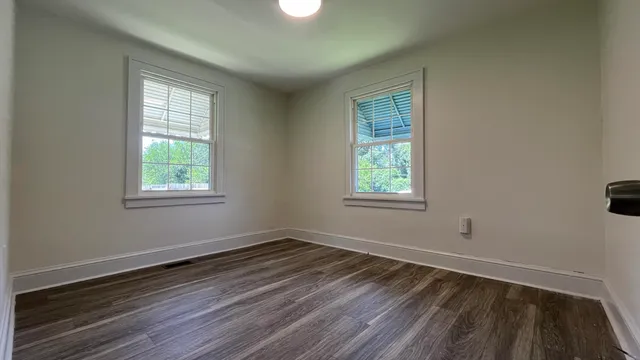 a view of a room with wooden floor and windows in it