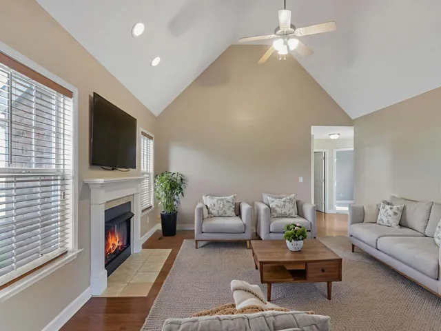 a living room with furniture a flat screen tv and a fireplace