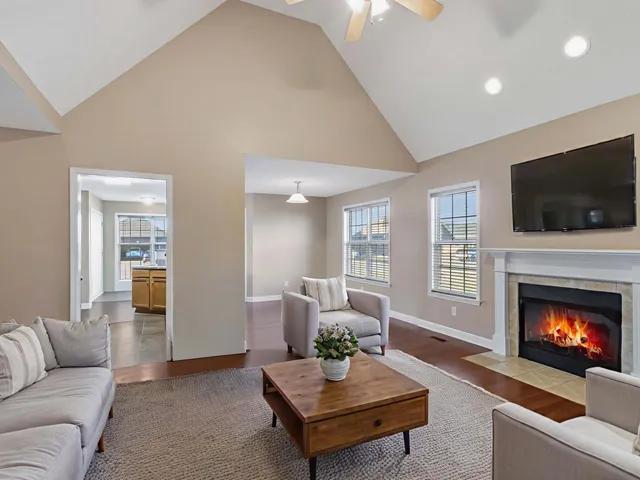 a living room with furniture a flat screen tv and a fireplace