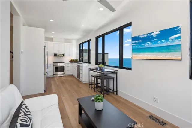 a living room with stainless steel appliances furniture and a large window