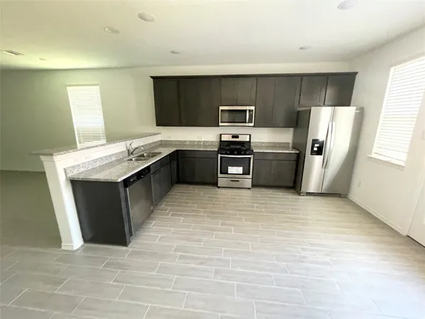 a kitchen with stainless steel appliances granite countertop a stove a refrigerator a sink dishwasher and a oven