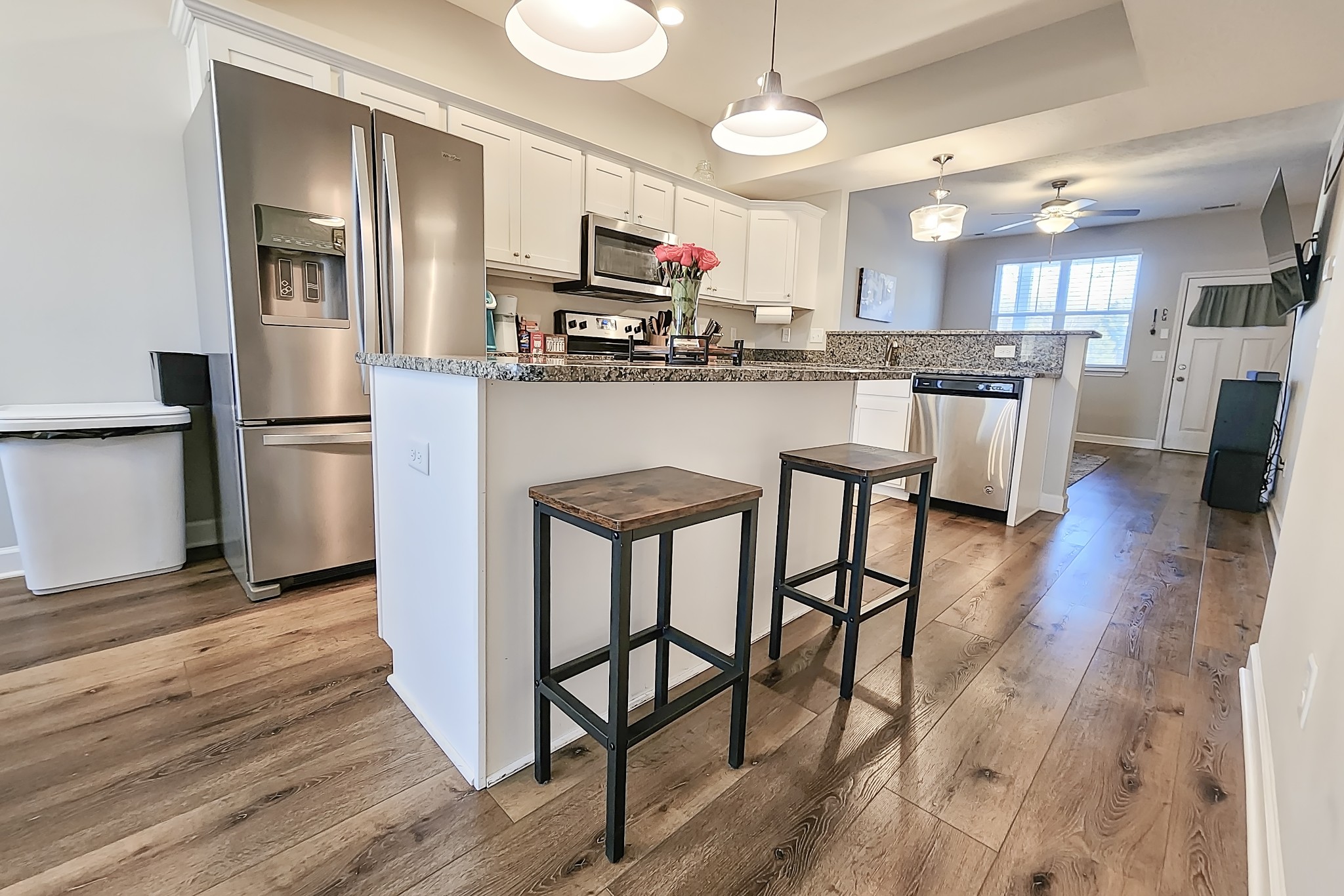 1382 Rural Hill Road, Unit 304 Antioch, TN 37013 - Photo 8 of 21 a kitchen with a refrigerator a microwave oven a sink dishwasher and white cabinets with wooden floor