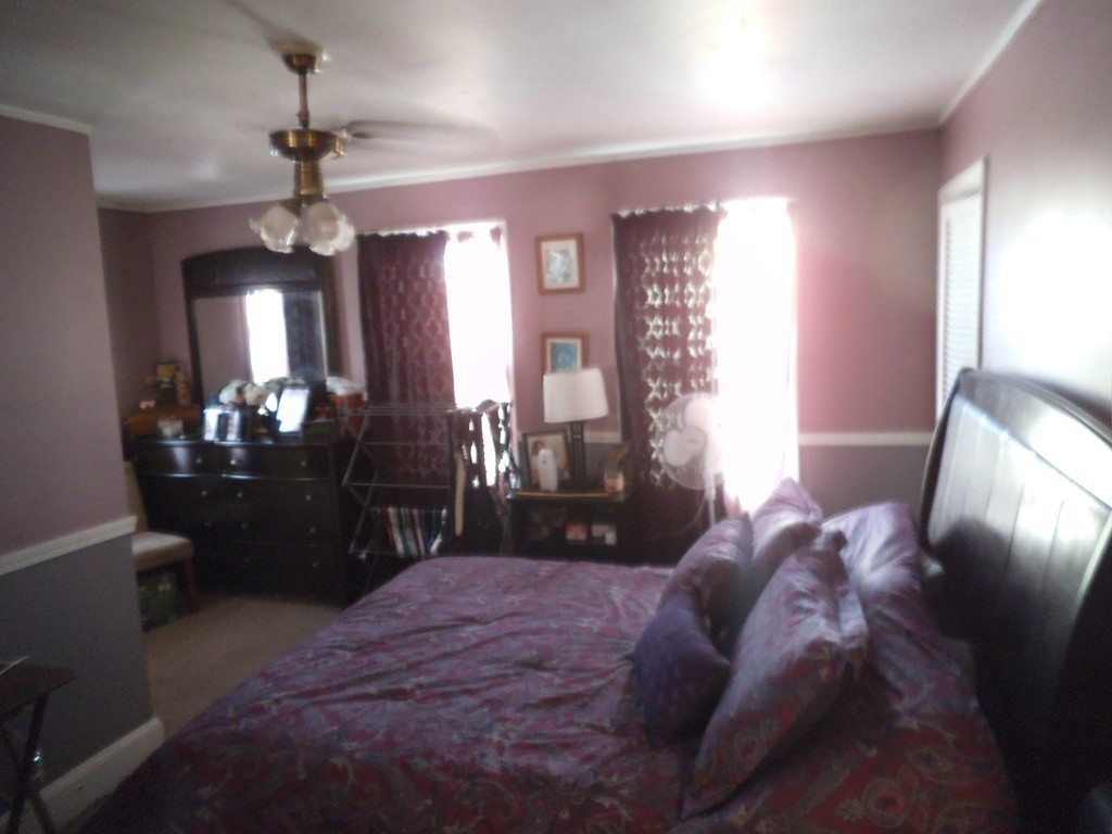 149 Franklin Street Fall River, MA 02720 - Photo 11 of 14 a bedroom with a large bed and a chandelier