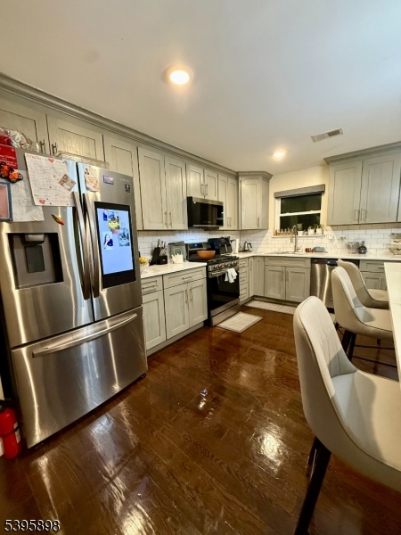 575 Hawthorne Avenue Newark, NJ 07112 - Photo 4 of 14 a kitchen with stainless steel appliances granite countertop a refrigerator a stove top oven a sink dishwasher and white cabinets with wooden floor