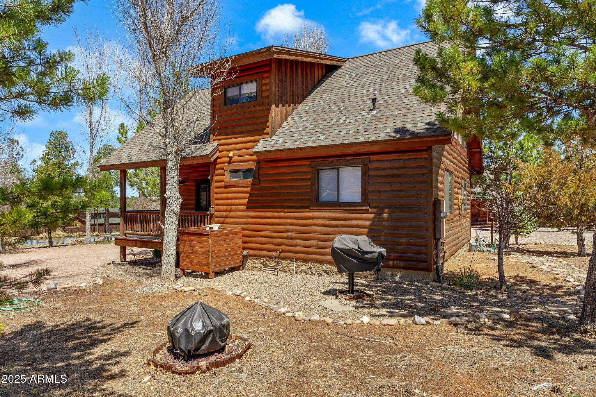 2300 Overgaard Springs Loop Overgaard, AZ 85933 - Photo 7 of 48 a backyard of a house with a table and chairs and a fire pit