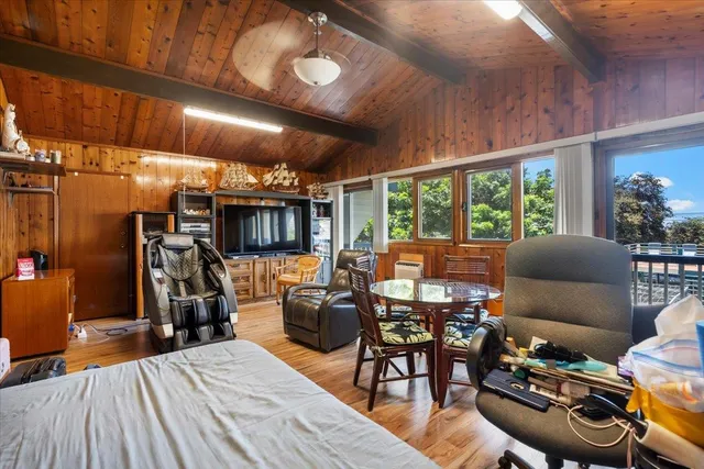 a living room with furniture a flat screen tv and a floor to ceiling window