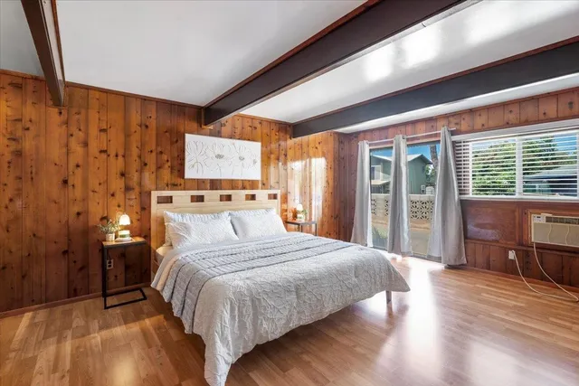 a bedroom with a large bed and wooden floor