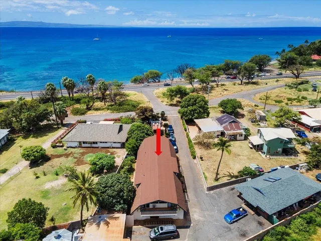 an aerial view of ocean and residential houses with outdoor space