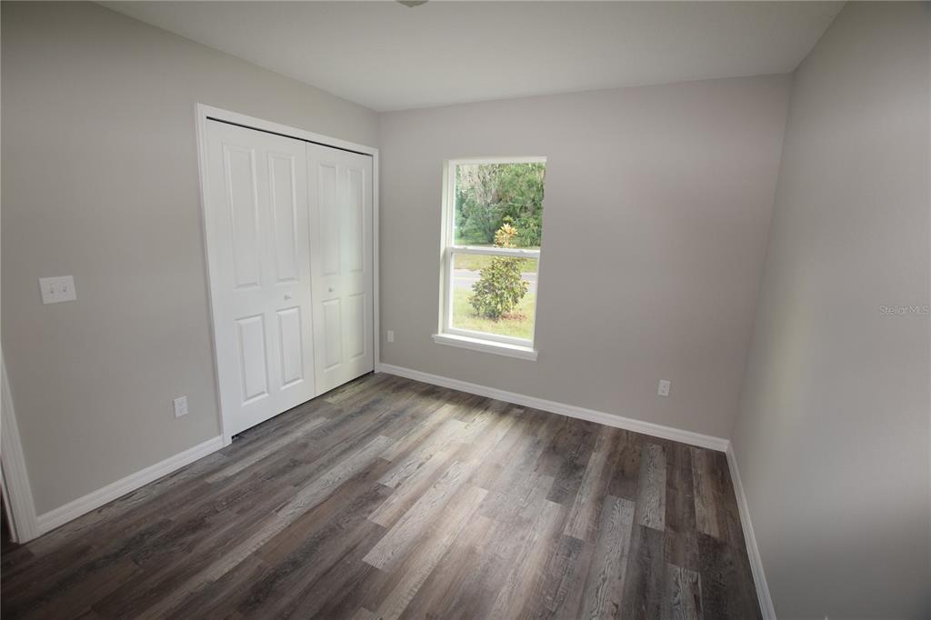 220 Danvers Street Eustis, FL 32726 - Photo 14 of 15 a view of an empty room with wooden floor and a window