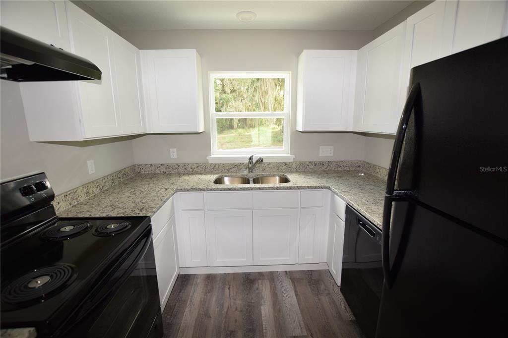 220 Danvers Street Eustis, FL 32726 - Photo 4 of 15 a kitchen with granite countertop a refrigerator stove and sink