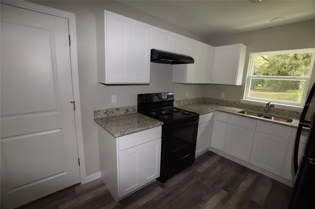a kitchen with a stove sink and cabinets