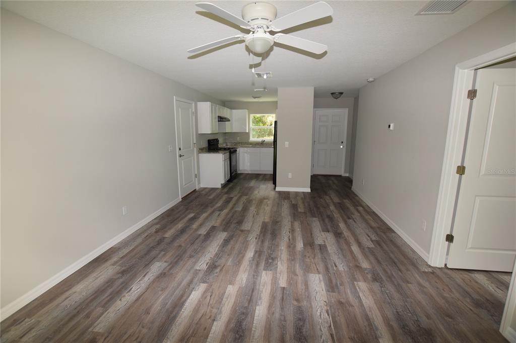 220 Danvers Street Eustis, FL 32726 - Photo 6 of 15 a view of empty room with wooden floor and ceiling fan