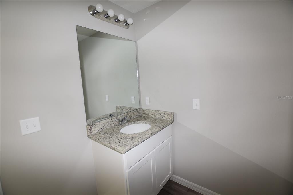 220 Danvers Street Eustis, FL 32726 - Photo 10 of 15 a bathroom with a granite countertop sink and a mirror