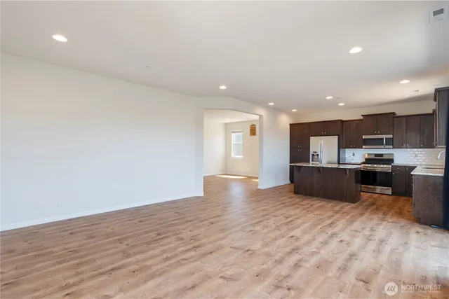a view of kitchen with kitchen island microwave and cabinets