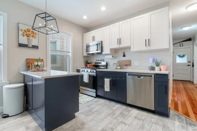 a kitchen with stainless steel appliances granite countertop a refrigerator and a stove top oven