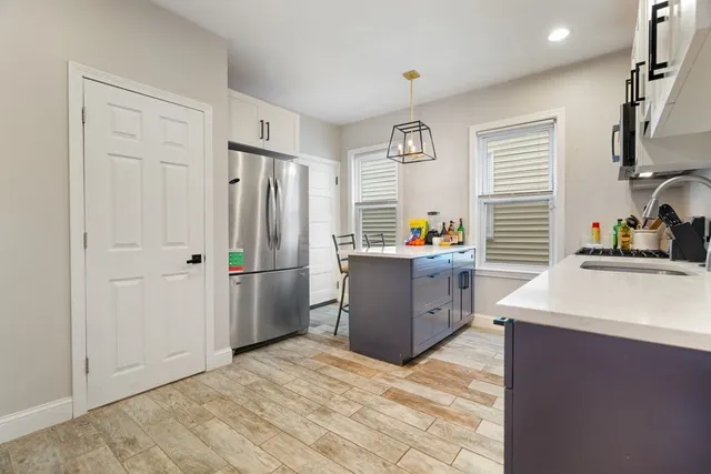 a kitchen with stainless steel appliances granite countertop a refrigerator sink and wooden cabinets