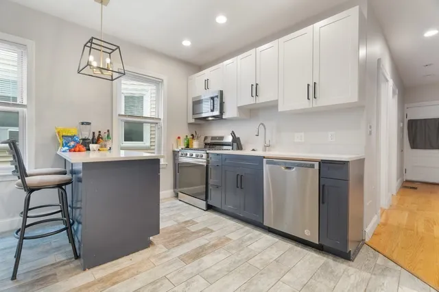 a kitchen with stainless steel appliances granite countertop a white cabinets and wooden floor