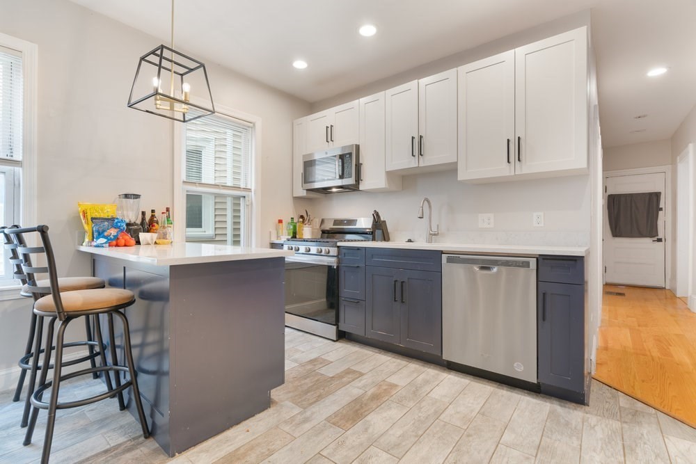 24 Buttonwood Street Boston, MA 02125 - Photo 35 of 42 a kitchen with stainless steel appliances granite countertop a white cabinets and wooden floor