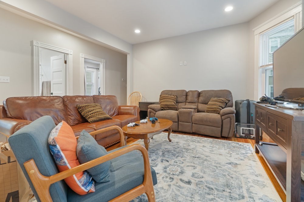 24 Buttonwood Street Boston, MA 02125 - Photo 39 of 42 a living room with furniture a couch and a stove top oven
