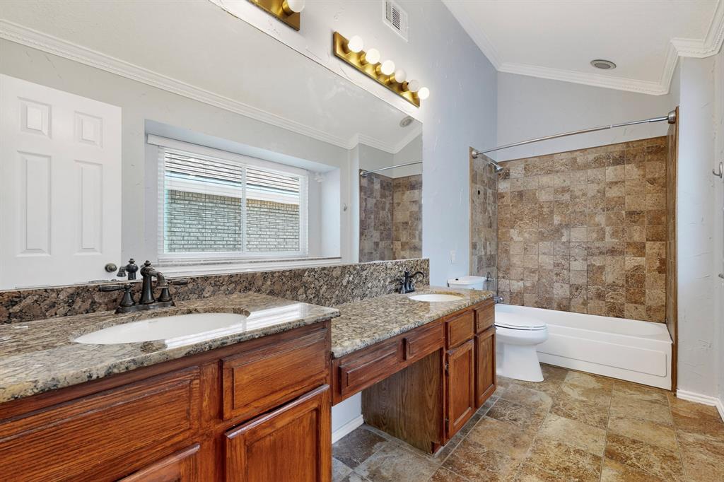664 Phillips Drive Coppell, TX 75019 - Photo 17 of 24 a bathroom with a granite countertop sink a toilet a mirror and bathtub