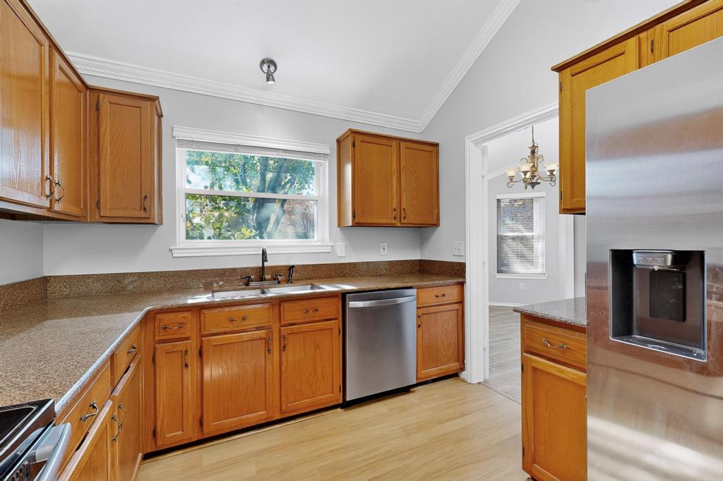 664 Phillips Drive Coppell, TX 75019 - Photo 8 of 24 a kitchen with stainless steel appliances granite countertop wooden cabinets a sink and dishwasher with wooden floor