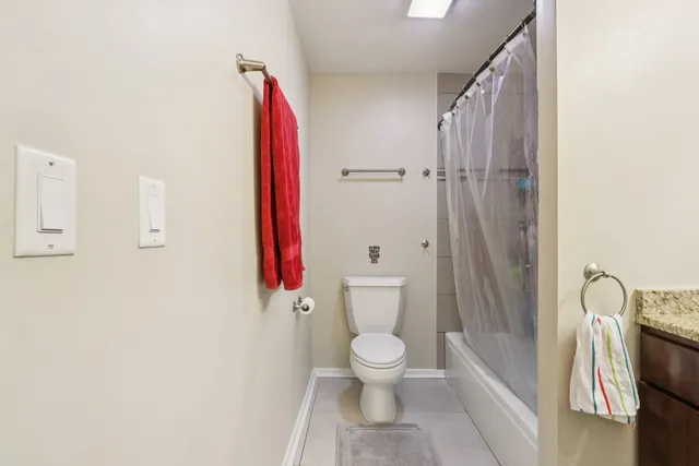 a white toilet sitting next to a bathroom sink and a shower