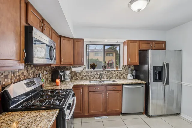 a kitchen with stainless steel appliances granite countertop a sink stove and refrigerator