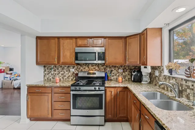a kitchen with sink a microwave and cabinets