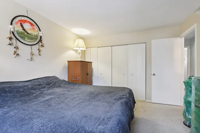 a bedroom with a bed and a painting on the wall