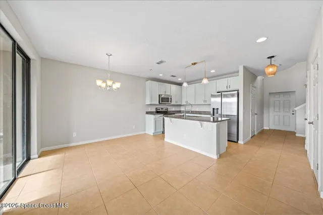 a view of kitchen with kitchen island white cabinets and stainless steel appliances